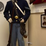 Civil War Corporal with the 9th Maine Volunteer Infantry Regiment. One of only two reproduction uniforms in the museum. The re-enactors uniform is accurate down to the buttons. The weapons are authentic.