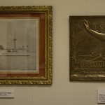 The framed print on the left is an original 1906 print of the USS Maine. The bronze plaque on the right was cast in 1913 from original pieces of metal taken off the USS Maine when she was taken out of the harbor in Havana into deep water and sunk. There were only 1000 castings of which fewer than 50 are known to exist today.
